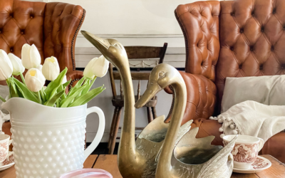 Vintage brass swans on a coffee table with a vase of tulips