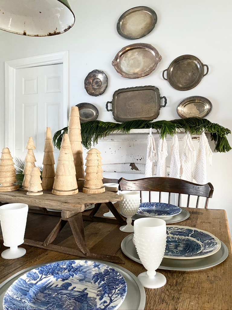 A Christmas Tablescape with a chippy holiday mantel in the background