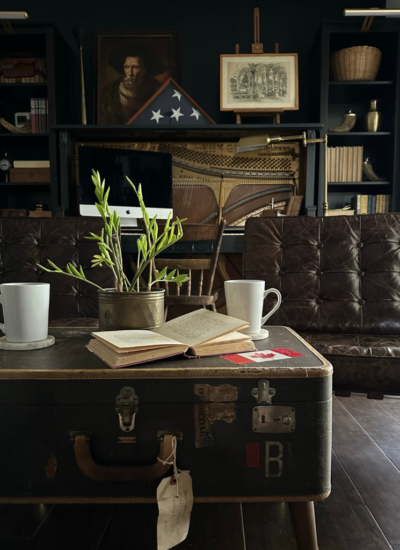 A view of our office featuring a vintage suitcase repurposed as a coffee table in front of a pair of Barcelona chairs.