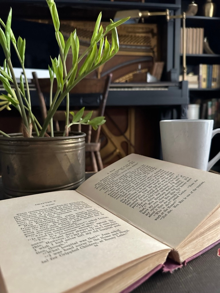 A vintage book lies open next to a mug of tea in the office.